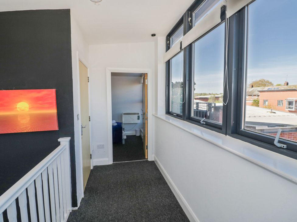 A hallway with a painting and access to the toilet at Apartment 10 Birmingham