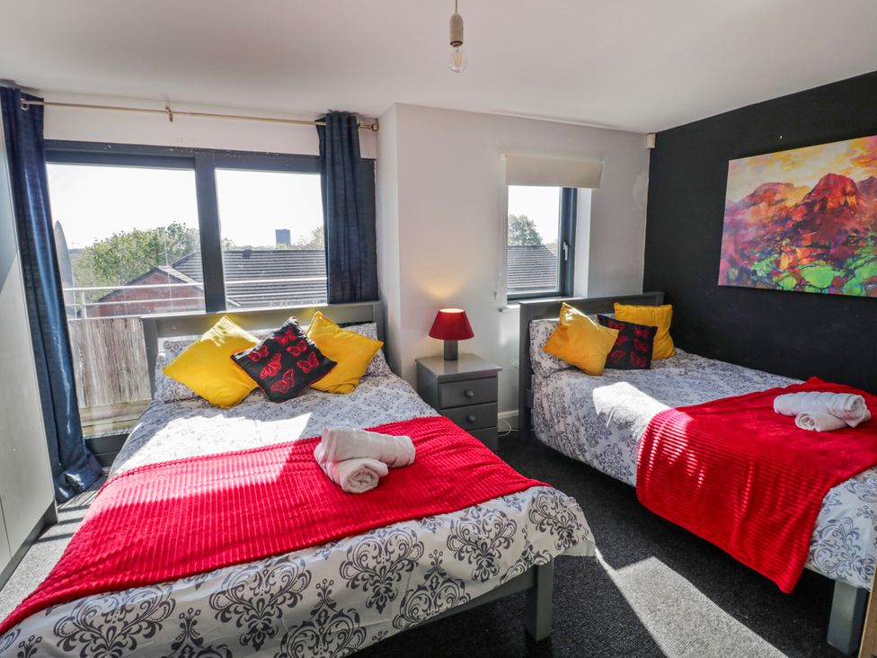 A bedroom with two beds and a lamp at Apartment 10 in Birmingham
