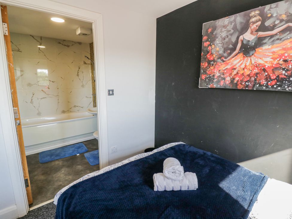 A bedroom with a bed and towel with a bathroom visible at Apartment 10 in Birmingham