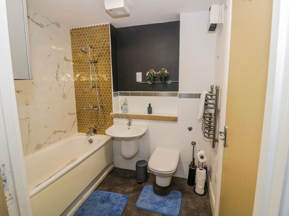 A bathroom with a bathtub, sink, and toilet at Apartment 10 in Birmingham