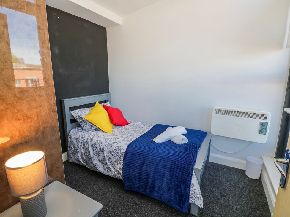 A bedroom with a bed and lamp at Apartment 10 in Birmingham