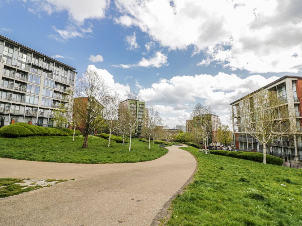 A pathway surrounded by grass and trees with buildings in the background at Apartment 10 in Birmingham