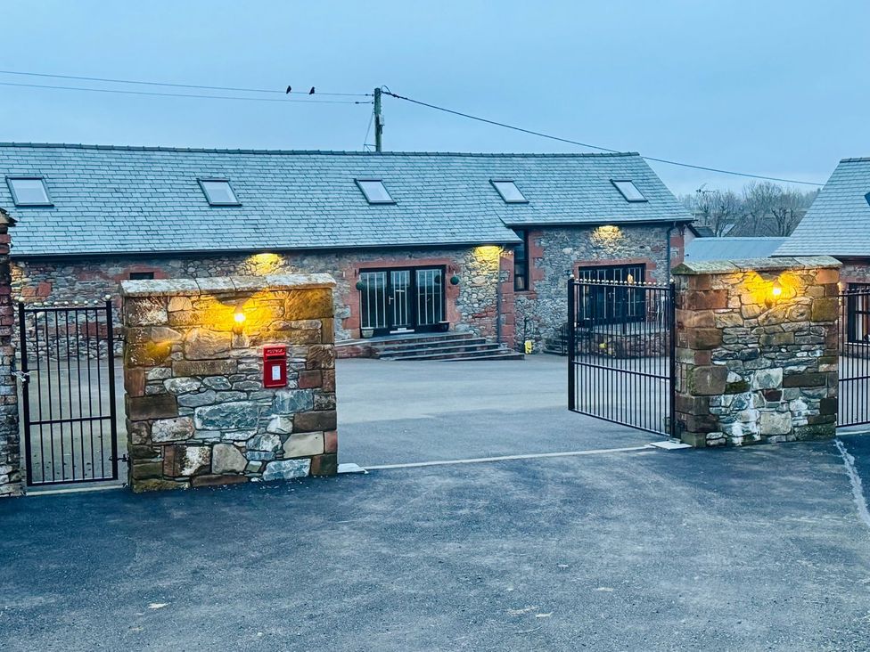 An outdoor view of a property entrance with a stone wall and gate at The Steading in Dumfries