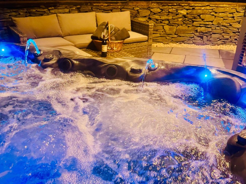 A hot tub with bubbles and a sofa at The Steading in Dumfries