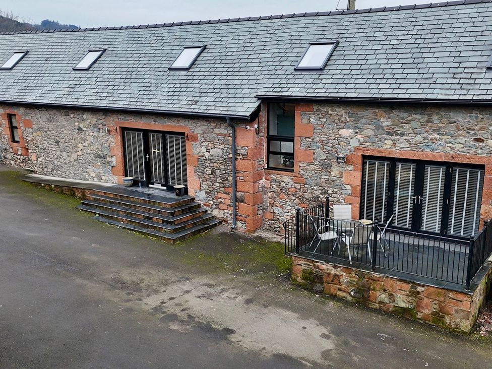 An outdoor area with steps leading to a stone building at The Steading in Dumfries