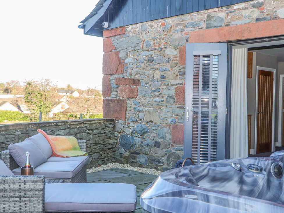 An outdoor seating area with a hot tub at The Steading in Dumfries