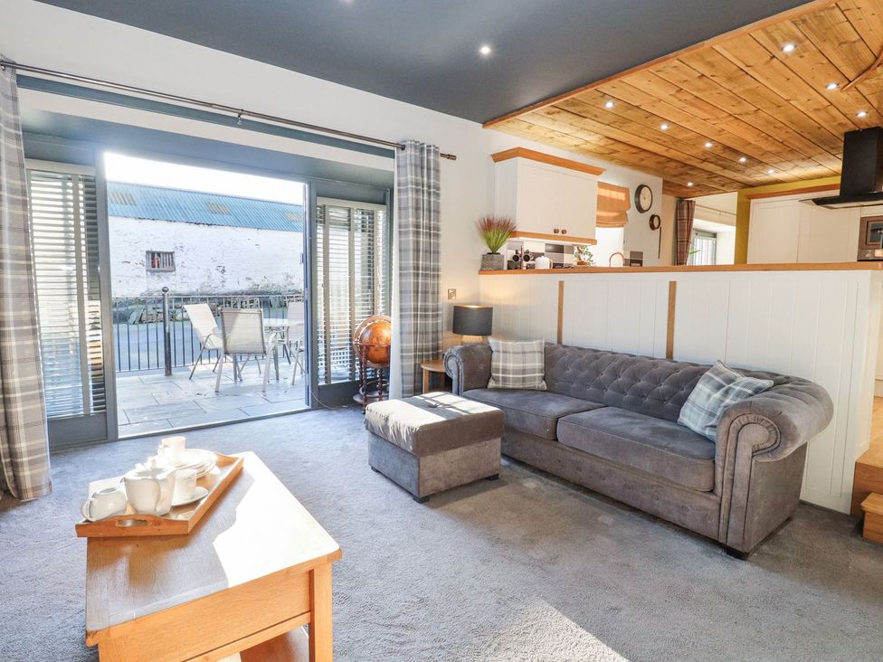 A living room with a sofa and a table at The Steading in Dumfries