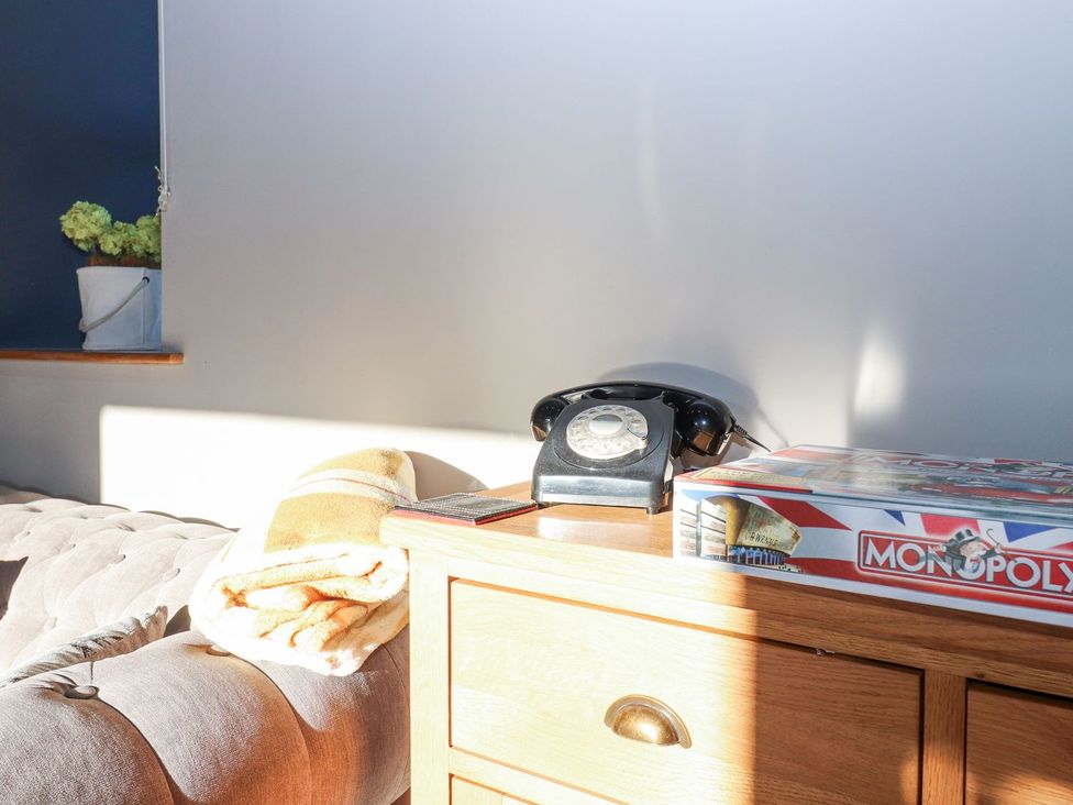 A living room with a telephone and a board game at The Steading in Dumfries
