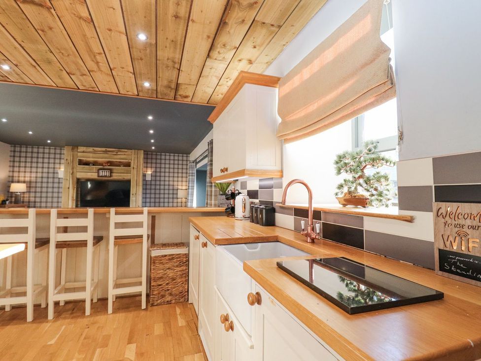 A kitchen with countertop and bar stools at The Steading in Dumfries