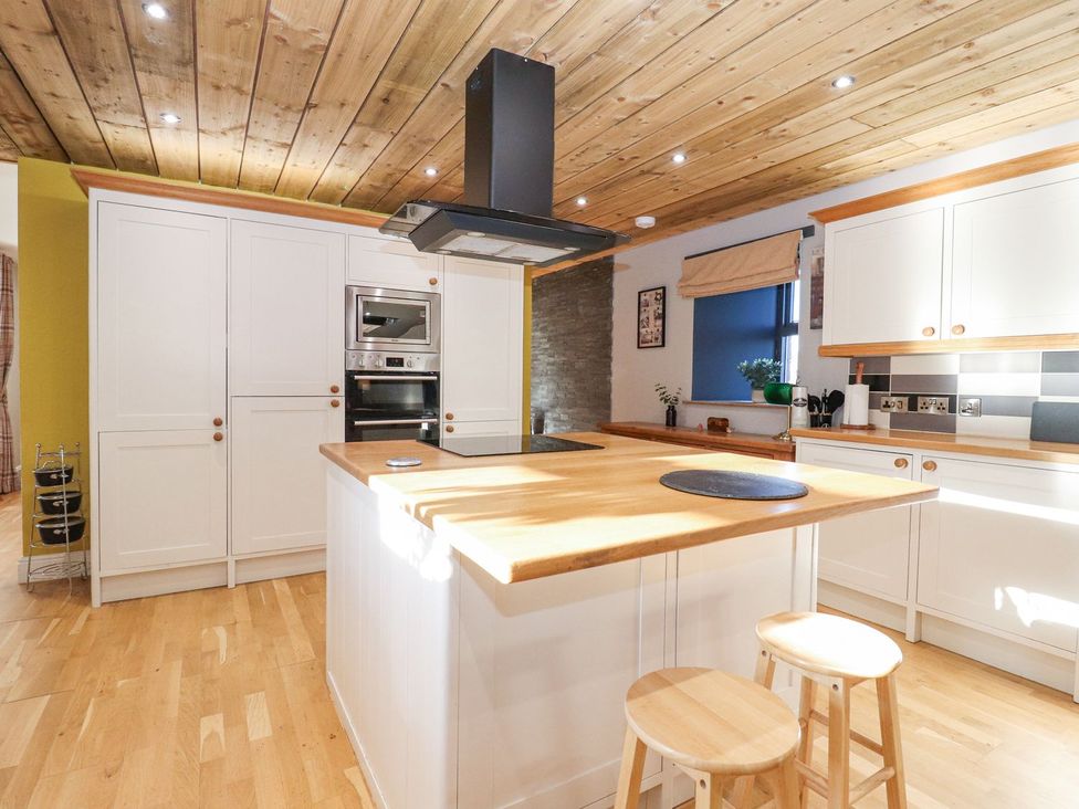 A kitchen with an island and cabinets at The Steading in Dumfries