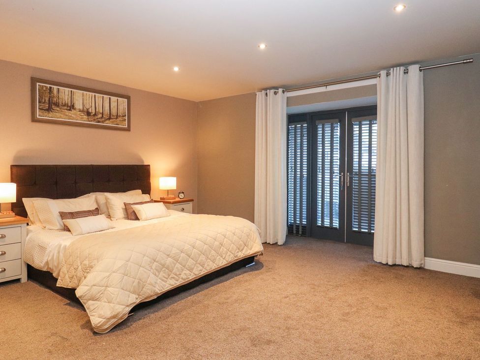 A bedroom with a bed and nightstands at The Steading in Dumfries