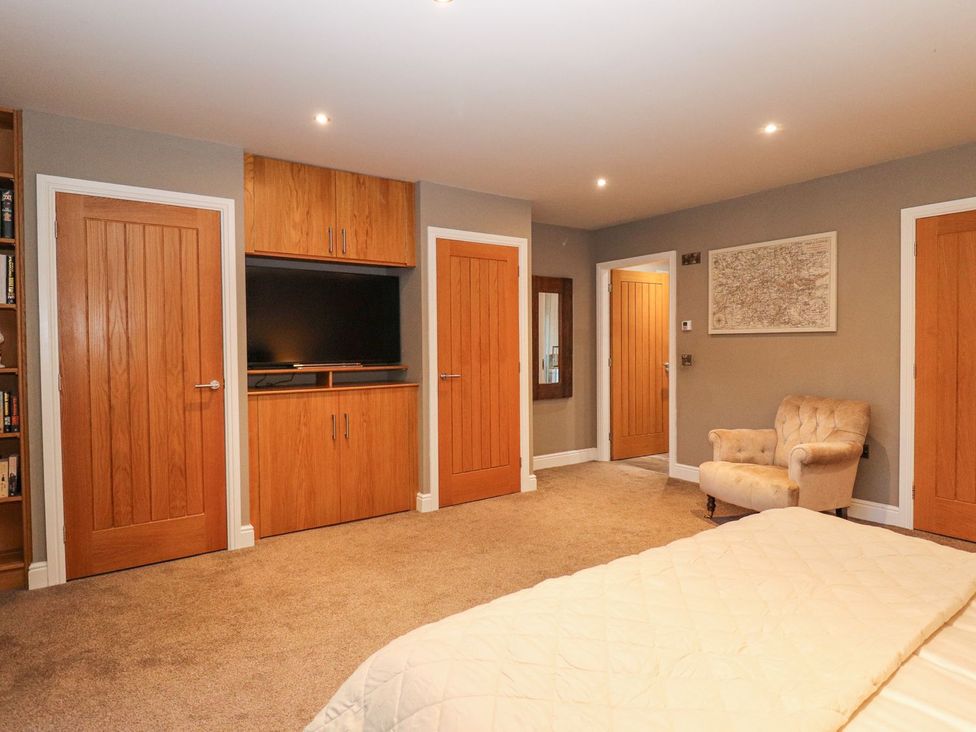 A bedroom with a television and doors at The Steading in Dumfries