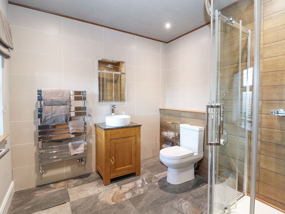 A bathroom with sink, toilet, towel rack and shower at The Steading in Dumfries