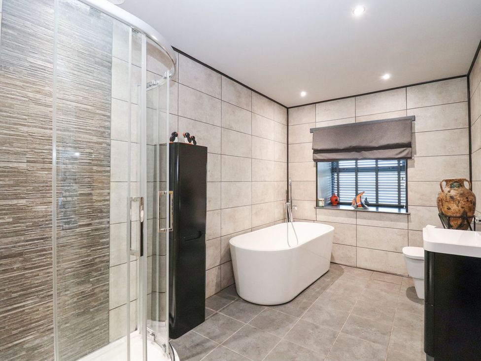 A bathroom featuring a shower, bathtub, sink, and toilet at The Steading in Dumfries