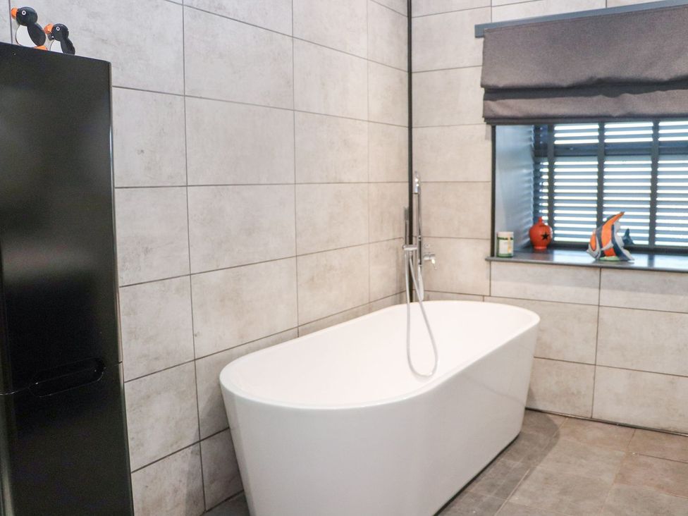 A bathroom featuring a bathtub and a window at The Steading Dumfries