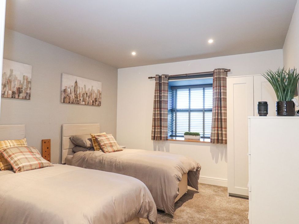 A bedroom with two beds and a window at The Steading in Dumfries