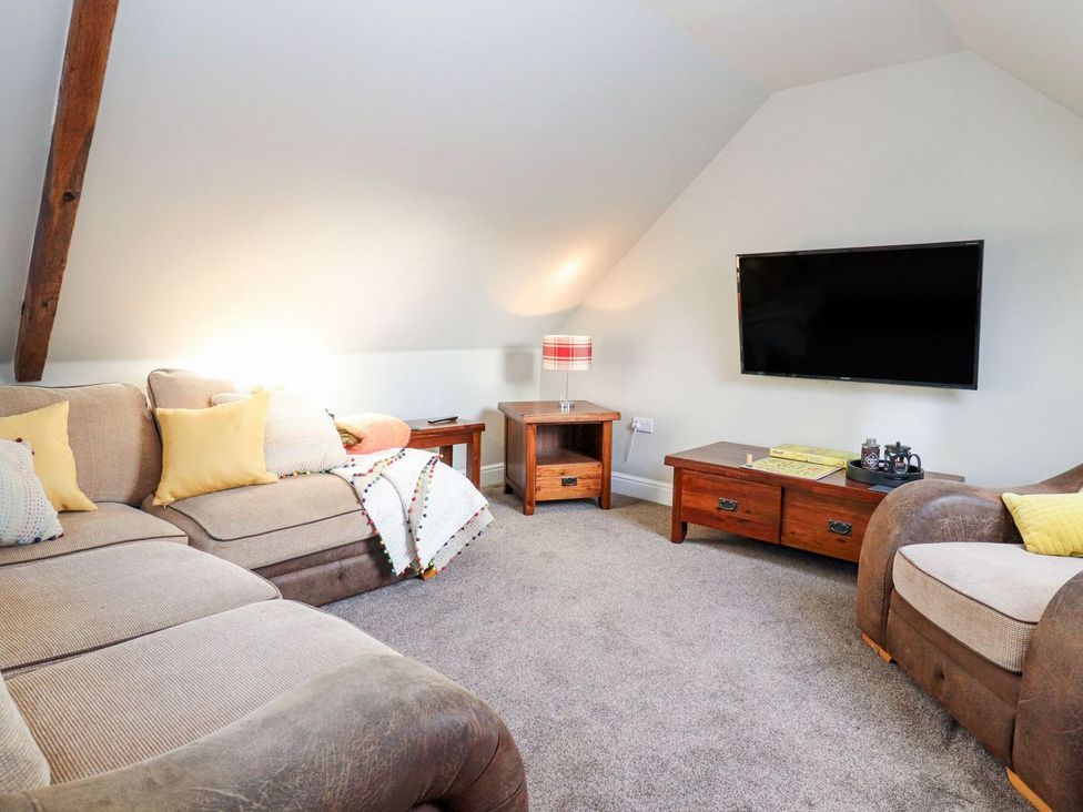 A living room with a television and sofa at The Steading in Dumfries