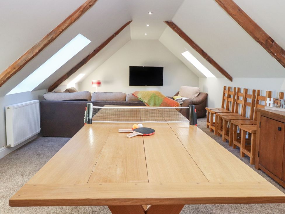 A recreational room with a ping pong table and sofa at The Steading in Dumfries
