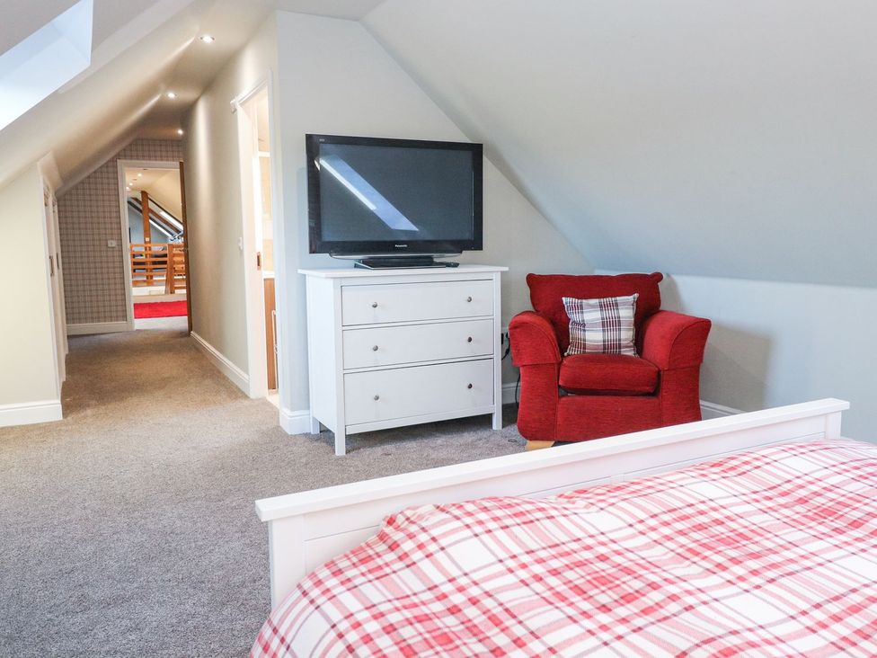 A bedroom with a bed and television at The Steading in Dumfries
