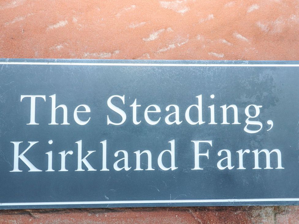A sign featuring The Steading, Kirkland Farm