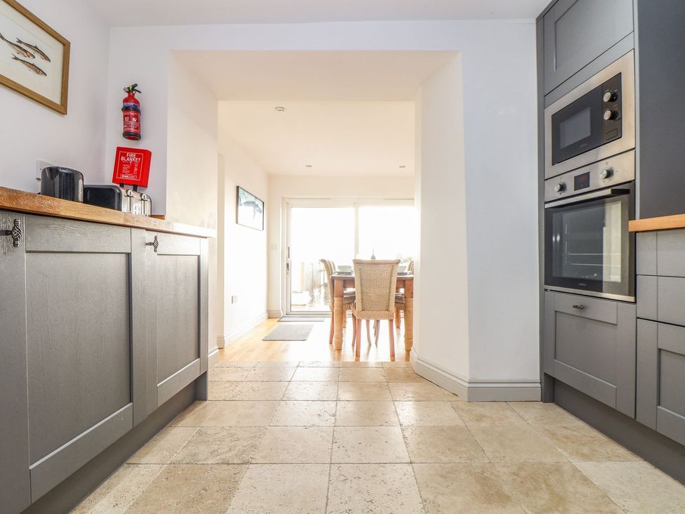 A kitchen with a dining area and appliances at Ty Bryn in Marazion