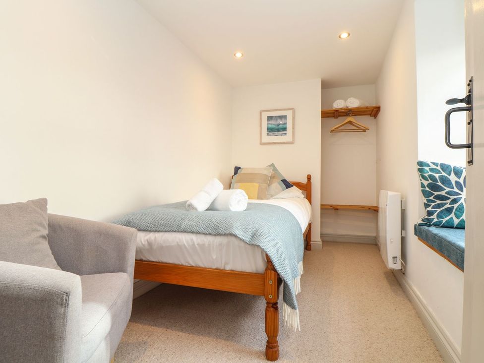 A bedroom with a single bed and chair at Ty Bryn in Marazion