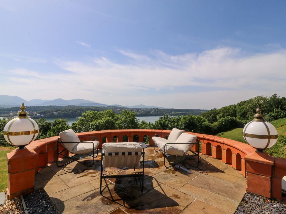 An outdoor patio with seating overlooking water at Apartment 1, Bryn Mel Manor Menai Bridge