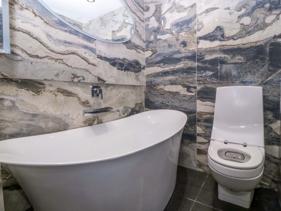 A bathroom with a bathtub and toilet at Apartment 1, Bryn Mel Manor Menai Bridge