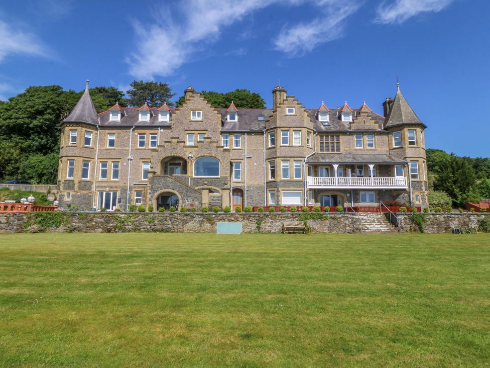 A large building with a lawn and trees at Apartment 1, Bryn Mel Manor in Menai Bridge