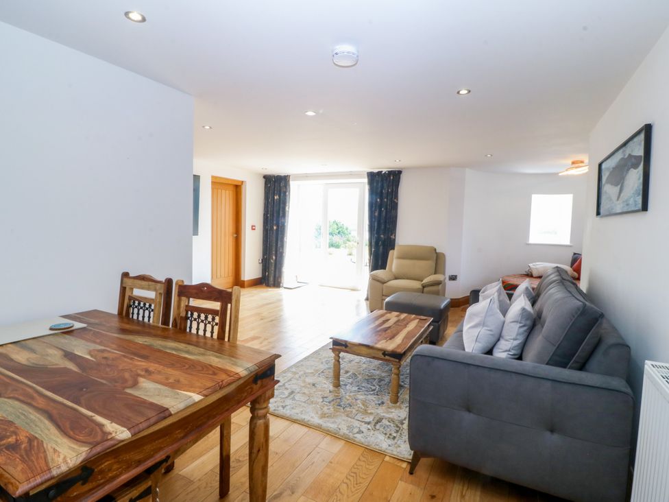 A living room with a dining table and sofa at Apartment 1, Bryn Mel Manor in Menai Bridge