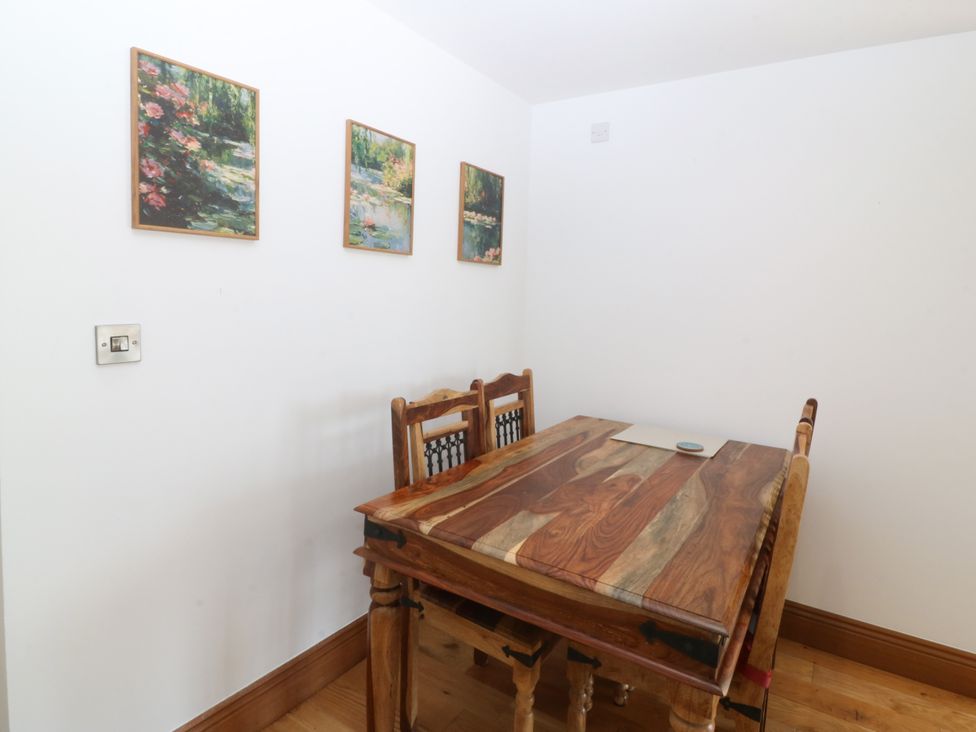A dining room with a wooden table and chairs at Apartment 1, Bryn Mel Manor in Menai Bridge