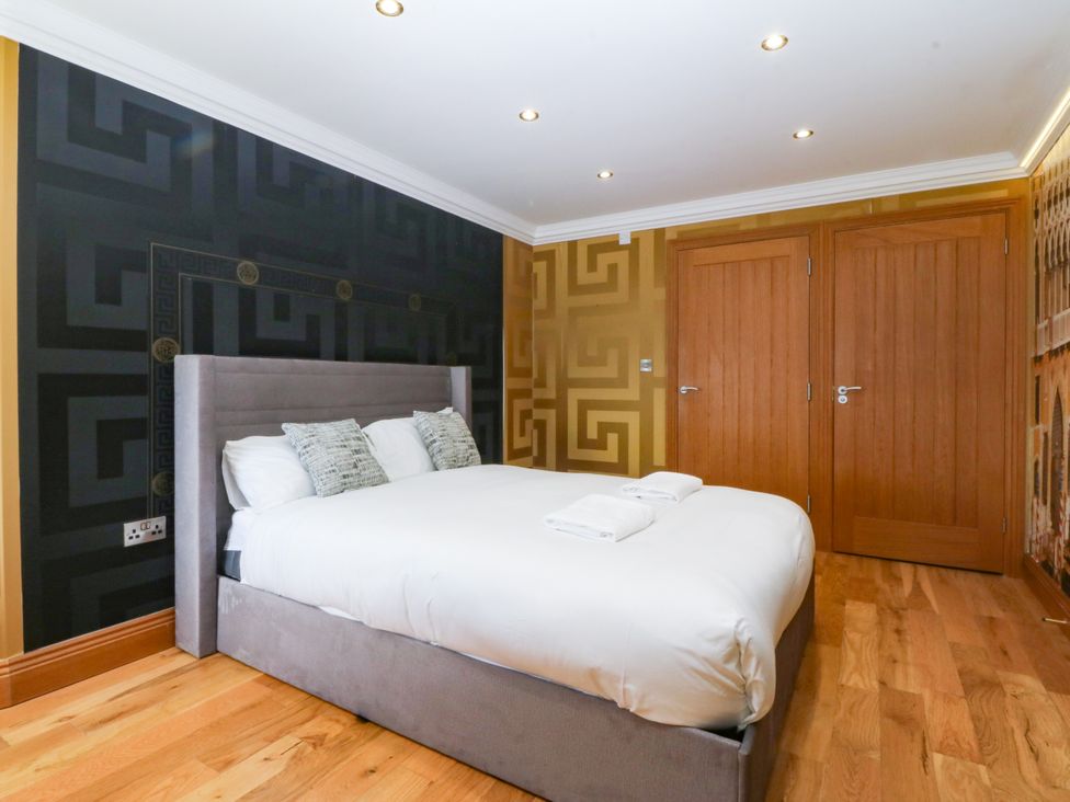 A bedroom with a bed and wardrobe at Apartment 1, Bryn Mel Manor in Menai Bridge