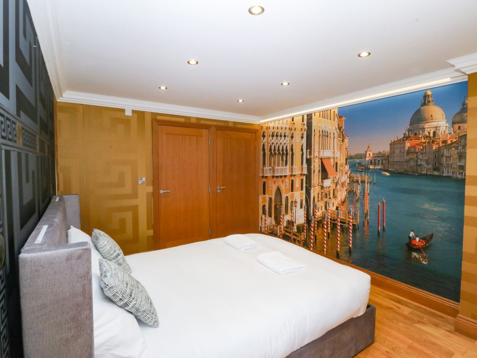 A bedroom with a bed and wall mural at Apartment 1, Bryn Mel Manor Menai Bridge