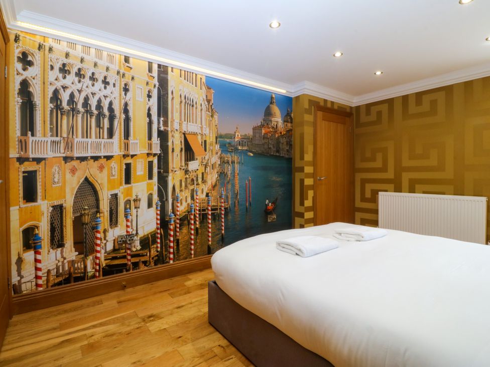 A bedroom with a bed and wall mural at Apartment 1, Bryn Mel Manor Menai Bridge