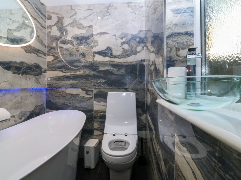 A bathroom with a tub, toilet, and sink at Apartment 1, Bryn Mel Manor Menai Bridge