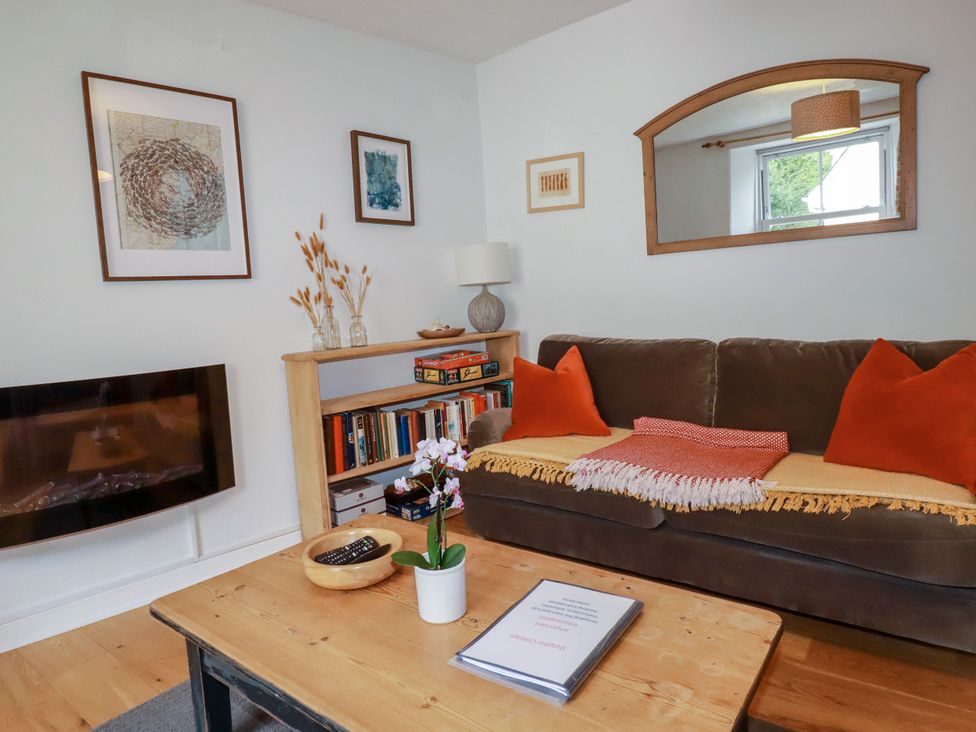 A living room with a sofa and a coffee table at Dolphin Cottage in Falmouth