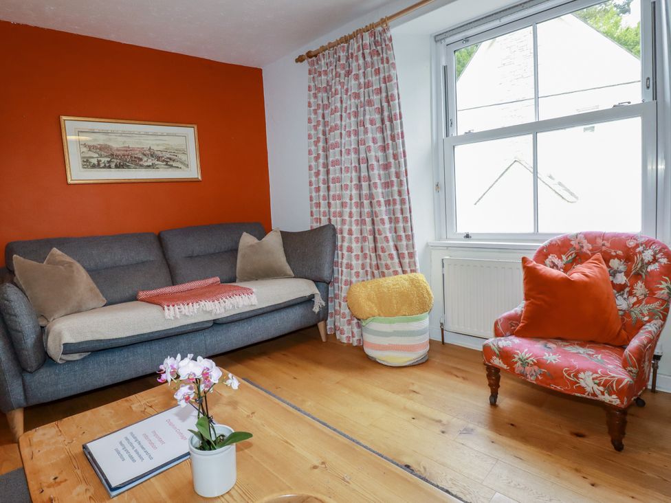 A living room with a sofa and armchair at Dolphin Cottage in Falmouth
