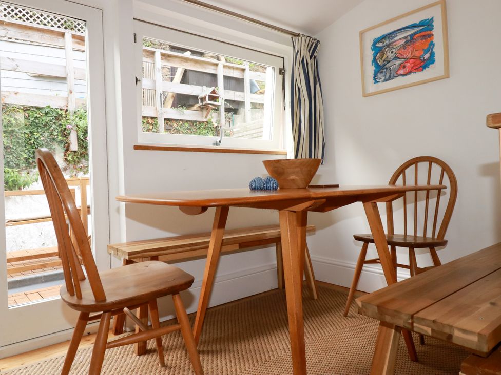 A dining room with a wooden table and chairs at Dolphin Cottage in Falmouth