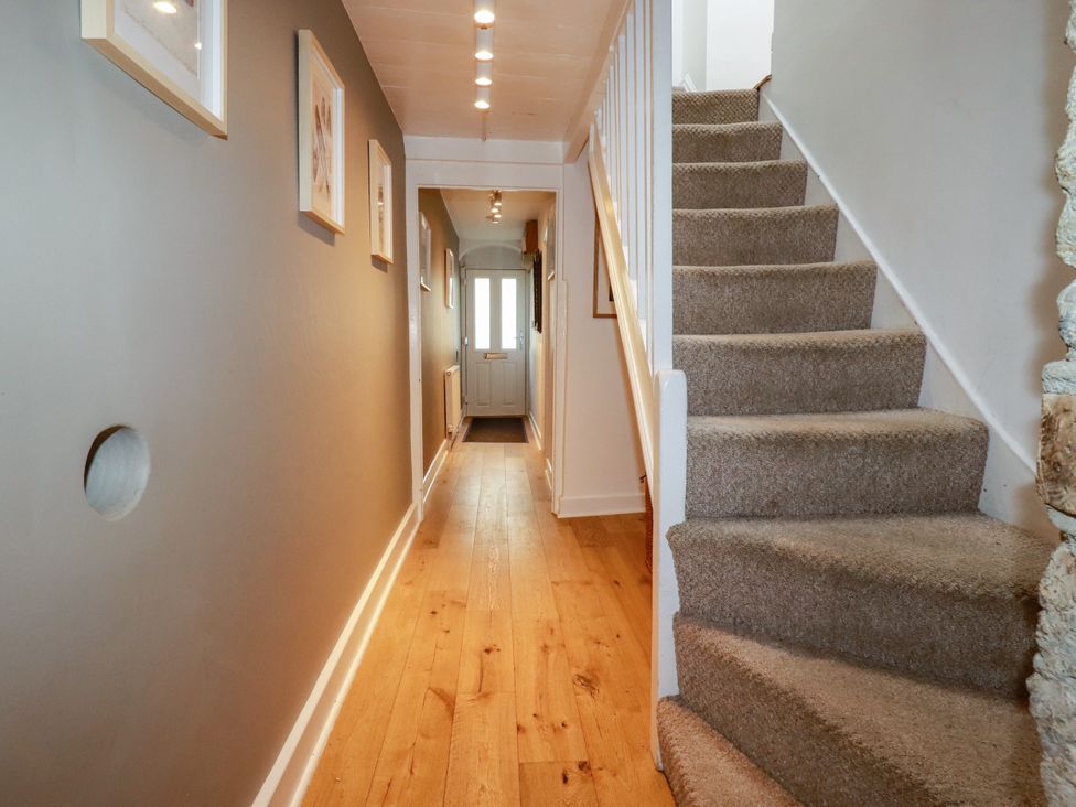 A hallway with stairs and a door at Dolphin Cottage in Falmouth