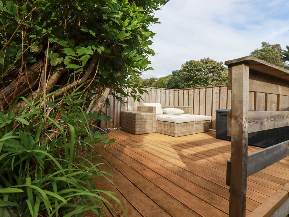 An outdoor seating area with a wooden deck at Dolphin Cottage in Falmouth