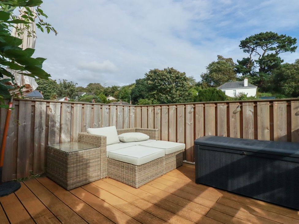 An outdoor patio with a sofa and table at Dolphin Cottage in Falmouth