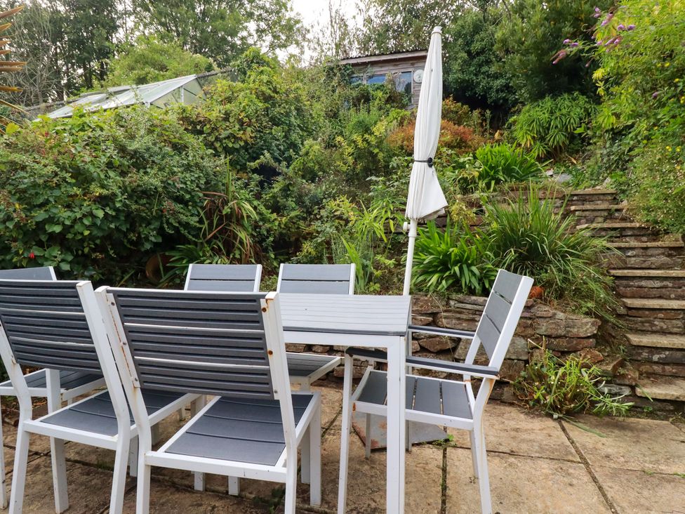 A garden with outdoor seating and steps at Dolphin Cottage in Falmouth