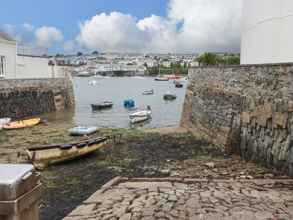 A view of boats in water with a stone wall at Dolphin Cottage in Falmouth