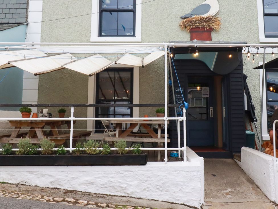 An outdoor seating area with tables and chairs at Dolphin Cottage in Falmouth