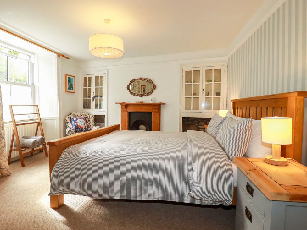 A bedroom with a bed and nightstand at Dolphin Cottage Flushing