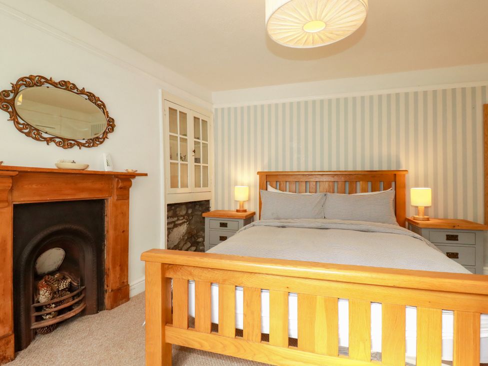 A bedroom with a bed and bedside tables at Dolphin Cottage in Flushing