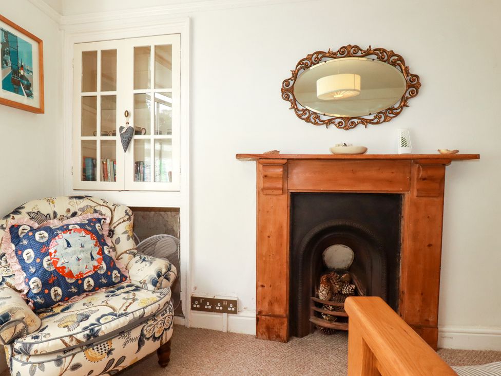 A living room with a chair and fireplace at Dolphin Cottage in Flushing