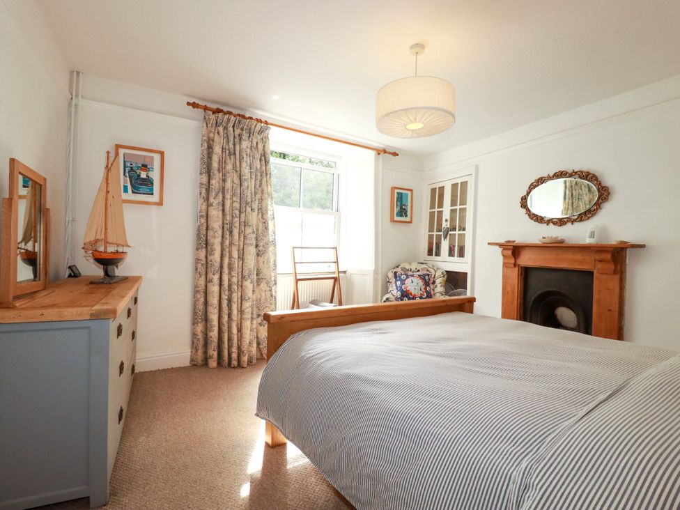 A bedroom with a bed and mirror at Dolphin Cottage in Flushing
