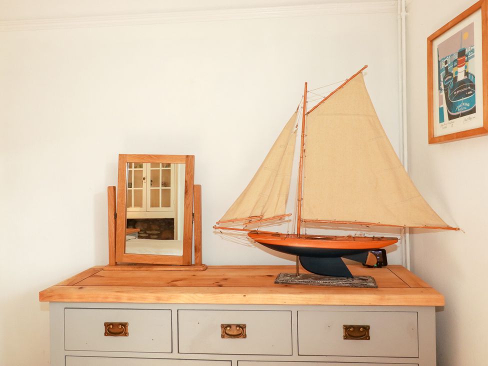 A sailboat and mirror on a cabinet at Dolphin Cottage in Flushing