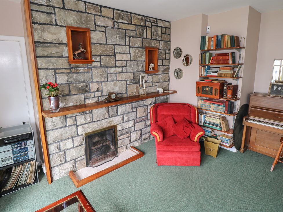 A living room with a fireplace and bookshelf at Sweetbriar Lodge in Castlerea